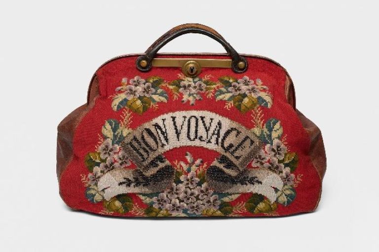 Rote Tasche mit Blumenstickereien und der Aufschrift "Bon Voyage"